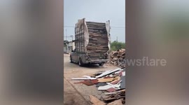 Filmer dodges wooden planks sliding down from truck