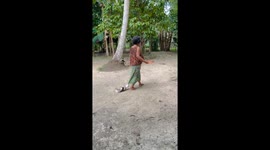Extra clingy pet chihuahua holds onto grandmother's sarong as she walks away