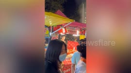 Pretty street vendor carries heavy bags and crates to her dessert stall