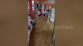 Pupils battle to scoop out floodwater at school in northeast Thailand
