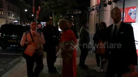 Kate Garraway departs the Suns Who Cares awards with a copy of the Sun Newspaper that features her in the same outfit as the paper was printed early