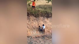 Resident fishes out two kids from bottom of dried-up pond with stick
