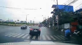 Motorcycle rider skids on wet road into path of oncoming car
