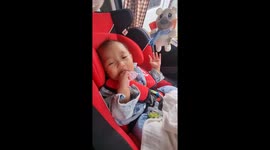 Cute baby struggles to stay awake while eating on car ride