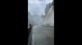 Raging waterfall sprays passers-by amid heavy rain in China