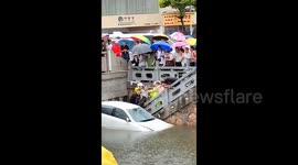 Police and residents rescue people trapped in car after it falls into river in China