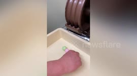 Baker makes skewered sweet dumplings using machine in Japan