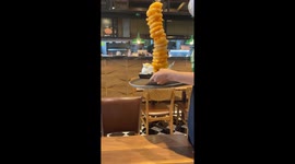 Onion ring tower covered with hot lava cheese looks delicious