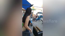 Kind onlooker helps struggling grandmother ride back of motorcycle taxi