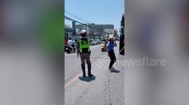 Traffic police dances along with performers from passing concert truck