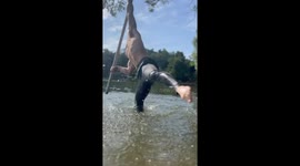Man Dances On Flying Pole Over Peaceful Lake