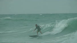 Surfers attemps to catch some waves during approaching Tropical Storm Ophelia off the North Carolina Coast