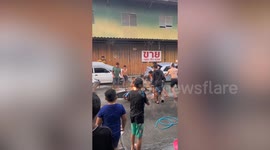 Songkran Festival-goers use buckets and wet shirts to put out motorcycle fire