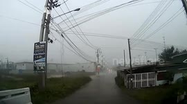 Storm blows warehouse onto oncoming car during storm in Thailand