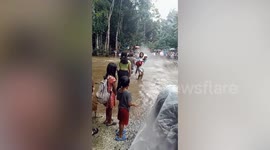 Residents brave flash flood surging on road amid monsoon storm