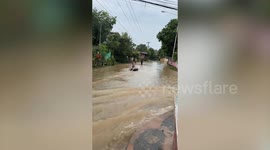 Woman goes 'tubing' on flooded steet in Thailand