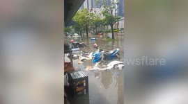 Motorcycles submerged by flash flood on road in Bangkok