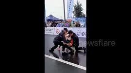 Quick-thinking security saves collapsing marathon runner at finish line in China