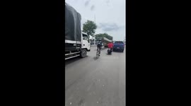 Cyclist changes lanes by riding UNDER huge concrete beams stretched from truck