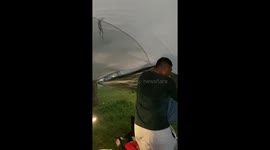Campers battle to control tent being blown around in storm