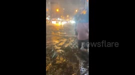 Bangkok residents wade through knee-deep floodwater as heavy downpours hit city