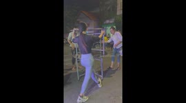 The woman used her head to lift two tables and dance in the middle of the street