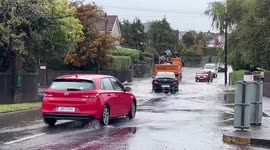 Cars drive through floodwater in Cork, Ireland