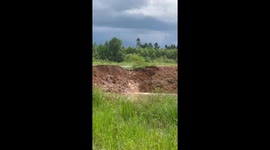 Water gushes through soil embankment eroded by floods in Thailand
