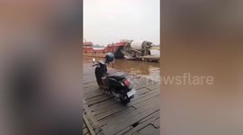 Cement mixer topples into river while boarding ship in Indonesia