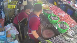 Fishmonger skillfully spins knife while waiting for customers
