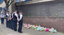 Police officers lay flowers at scene of stabbing in Croydon, London