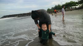 Baby Plays for the First Time on the Beach, Enjoying the Waves and Playing in the Sand