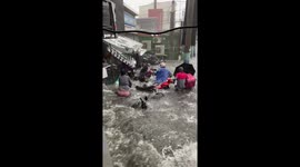 Wave on flooded road smashes into locals in Manila