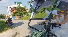 Couple ride away from wedding in electric tricycle cart