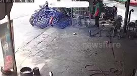 Pickup truck crashes into shop and scatters tricycles where a worker sits