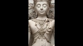 Adorable white kittens poke out from hole in Buddha monument