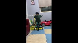 Toddler topples backwards while trying to ride push bike up a slide