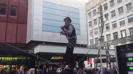 Man plays violin while tightrope walking in Manchester