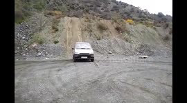 Man drives old hatchback up steep hill backwards