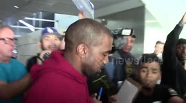 Kanye West mobbed on arrival at LAX airport