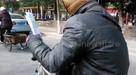 Man reads book while driving
