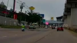 Motorcycle rider skids out of control when she drives over large pothole