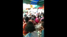 Frantic villagers clamour for free food handed out from truck