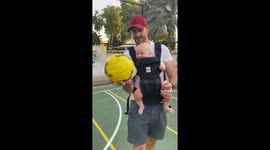 Baby boy giggles with delight as talented dad humors him by spinning ball on finger