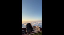 Cloud nine! Friends snuggle up on mountaintop as clouds move below them