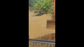 The brave excavator driver moves the excavator into the floodwater to change the flow of the water