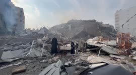 Palestinians inspect the ruins of Watan Tower destroyed in Israeli airstrikes in Gaza city.