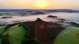 A spectacular misty sunrise at Colmers Hill at Symondbury near Bridport in Dorset, UK during the autumn heatwave.