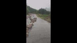 Hundreds of blocks of soil and rock buried the road after a flash flood caused landslides
