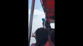 Chinese tourists compete with funny poses hanging from speedboats